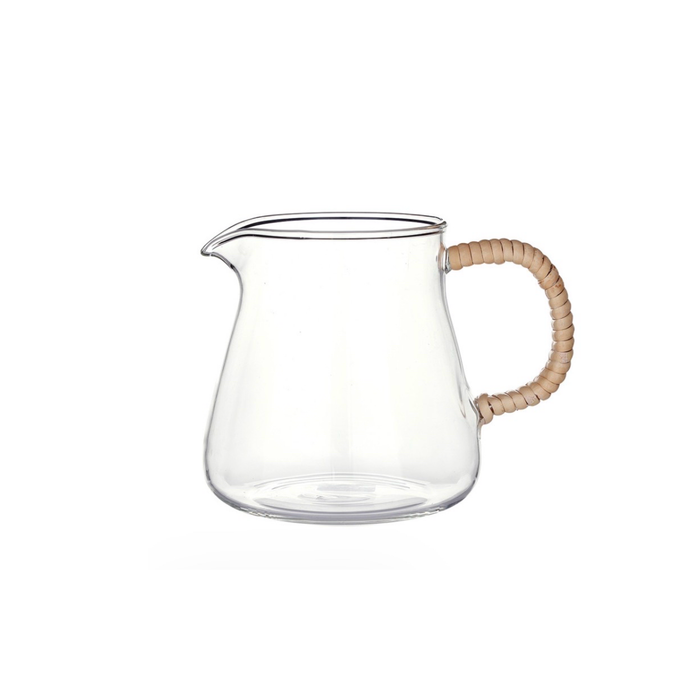 Clear glass pitcher with a rattan wrapped handle on a white background. Holds 20 fl oz.
