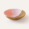 Small basket bowl hand woven in coils of natural sweetgrass with an abstract pattern in pale pink and coral. 8 inch diameter x 2 inch depth.