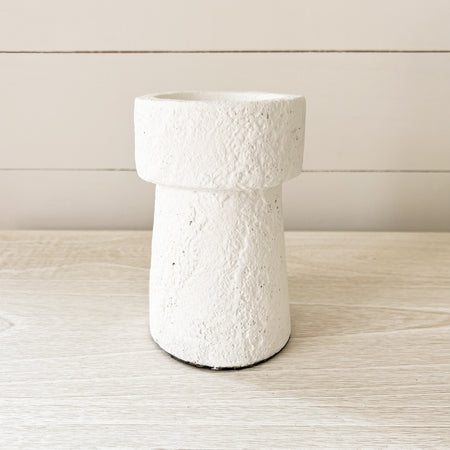 Tulum candle holder, small. 6.25" height x 3.75" diameter. Rustic stoneware candle holder in a modern sculptural silhouette finished with a textured matte white lava stone finish. Holds a 3" diameter pillar candle. 