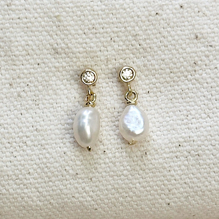 Pair of white pearl drop earrings with a CZ stud and gold fittings on a neutral canvas background. 18K gold filled, with Fresh water Baroque Pearl. 15mm length.