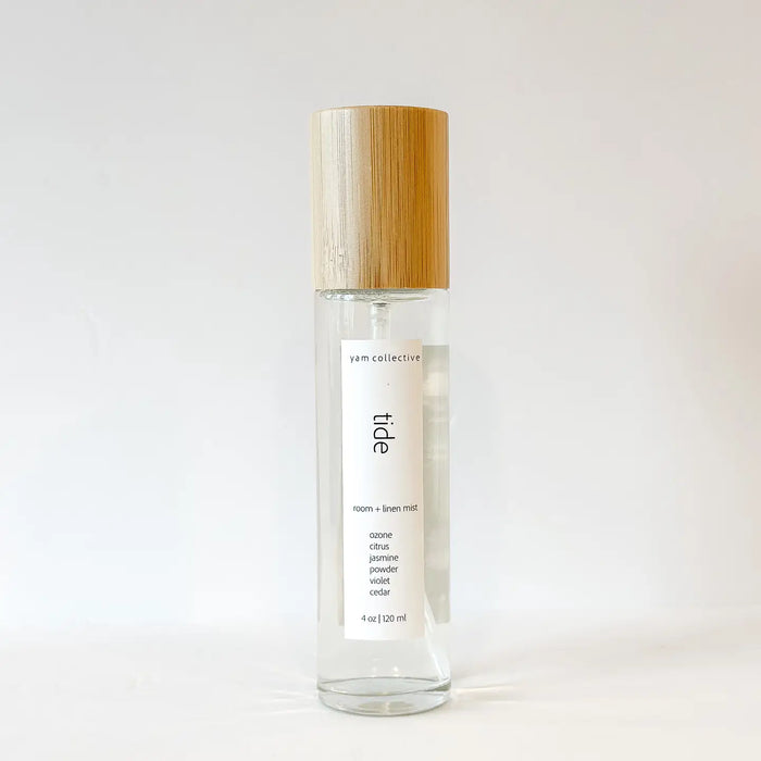 Clear spray bottle with wooden cap containing TIDE linen and room mist. Fragrance notes of Jasmine, Cedar, Violet and Citrus. 4 fl oz. 