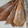 Collection of hand dyed cotton bandanas in shades of terra cotta and cream. Each piece will vary. 