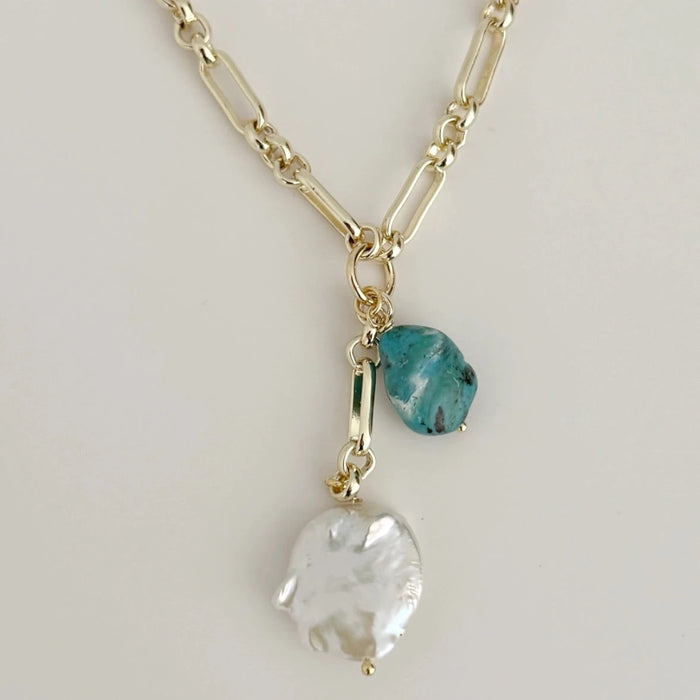 18k gold filled chain necklace adorned with a natural turquoise stone and a large white Baroque pearl charm. 16.5 inch length with 2 inch extender.