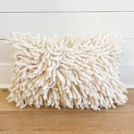 Ulla Pillow in natural unbleached luxuriously thick New Zealand wool. Front is tossled tufts of thick wool yarn on a basket weave base. Artisan made in 100% New Zealand wool. 14" x 20". Down insert included.