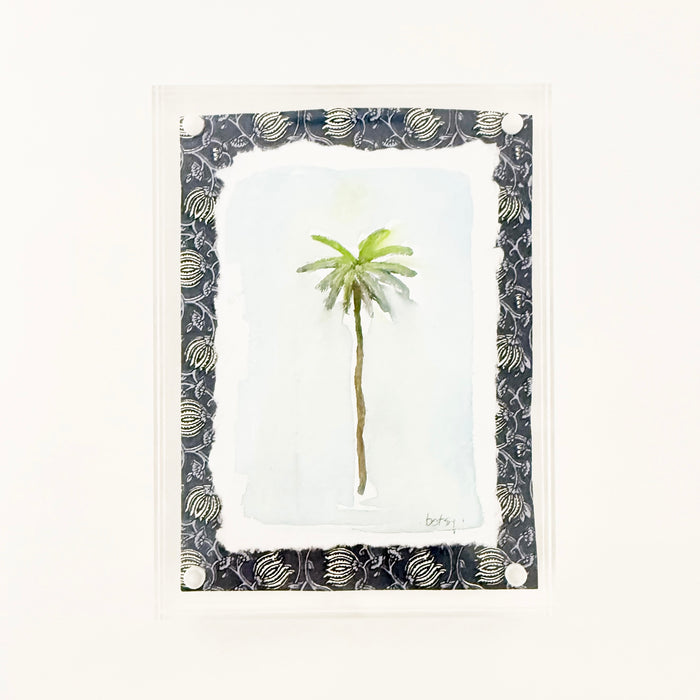 Framed watercolor of a palm tree with decorative indigo and white block print matter in a clear lucite block. Measures 6" x 8"