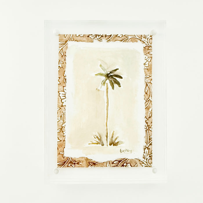 Watercolor of a palm tree with a neutral block printed matte framed in a clear lucite block. Measures 6" x 8"