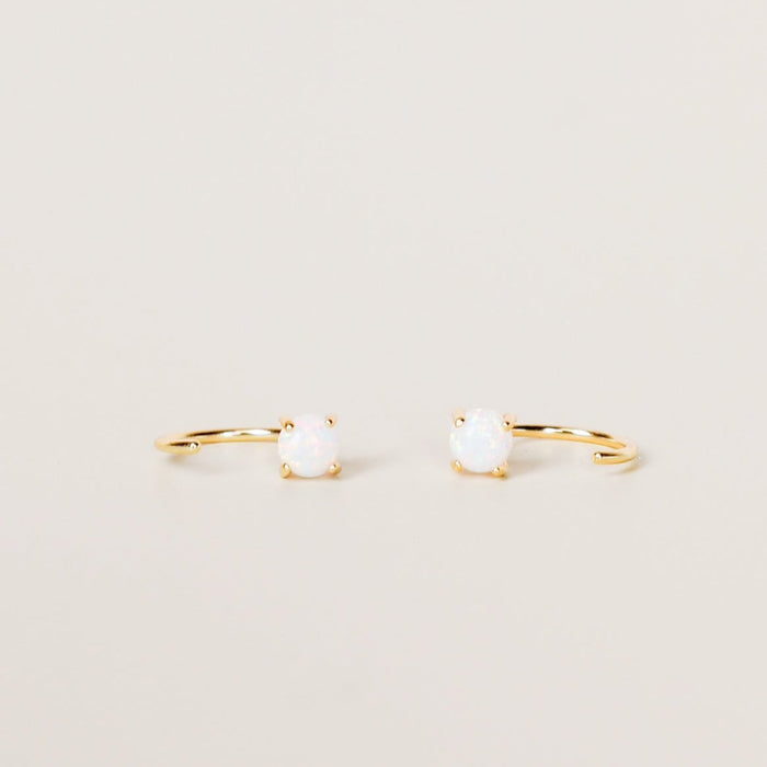 White Opal Huggies. Two open ended gold hoop earrings that loop through and gently hug the ear. Hoop is gold vermeil on sterling silver base with a smooth white Opal stone on one end.  