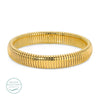 Gold coil bangle. Waterproof. 18K gold PVD plating over premium stainless steel. .46 inch width. 7.5 inch circumference.
