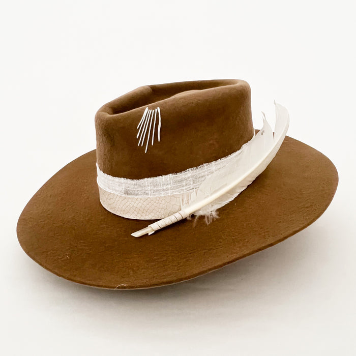 Wild Soul Hat custom made by La Macarena Hats in Tulum Mexico. A tobacco colored fine wool hat wrapped with an ivory snakeskin band, a white cotton gauze ribbon and finished with hand embroidery and a dramatic white feather.