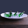 Shallow oval shaped matte white melamine serving bowl containing ice and green glass bottles. Made by Beatriz Ball. X Large Oval Bowl: 22.5 13 x 3.75 inches.