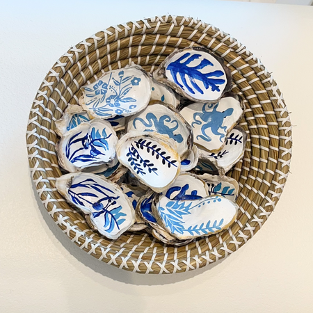 Assortment of hand painted oyster shells adorned with graphic foliage inspired by Matisse in shades of blue. Each sold separately. Each differs.
