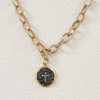 Close up of smoke pearl disk pendant with a diamond chip cross. Chain is 14k gold plated on 925 silver. 18.5" length.