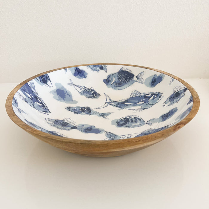 Pesce Serving Bowl. Natural mango wood bowl with a white food safe resin interior featuring a blue watercolor fish design. 12.75" diameter, 3" depth.