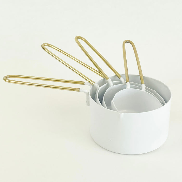 White enamel and brass handle measuring cups. Set of 4 includes 1 c, 1/2 c, 1/3 c and 1/4 c. A bright and stylish essential for the modern kitchen.