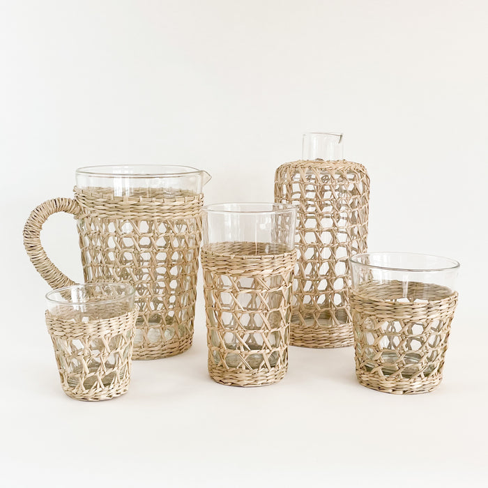 The Seagrass cage glassware collection. Artisan made from recycled glass and wrapped in a hand woven seagrass cage. Perfect for the natural table. Each piece sold separately. 