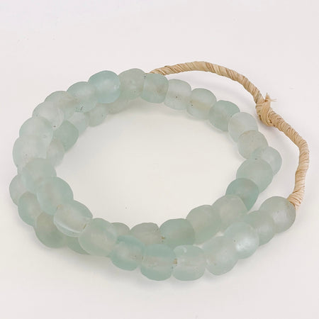 Seagrass Beads are made from recycled glass and are the perfect accent to any coastal decor. Style them in a bowl or layer them over the neck of a lamp. Hand made in Ghana. Measures approximately 26" length, 14mm bead.