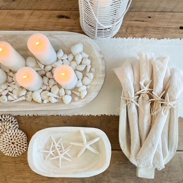 Our Whitewash Wood serving collection is hand carved from Paulownia wood. The bowl, tray and platter are all sold separately. Shown styled with white candles, natural shells and washed linens for a boho coastal tablescape.