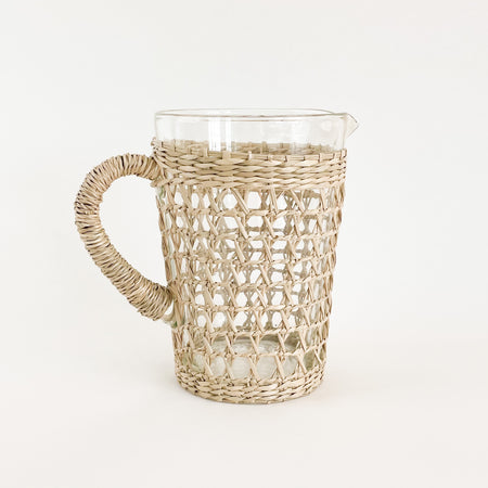 The seagrass pitcher is perfect for the natural table. Made from recycled glass and wrapped in a hand woven seagrass cage. Measures 7.5" H 5" D at mouth and 4" D at base.