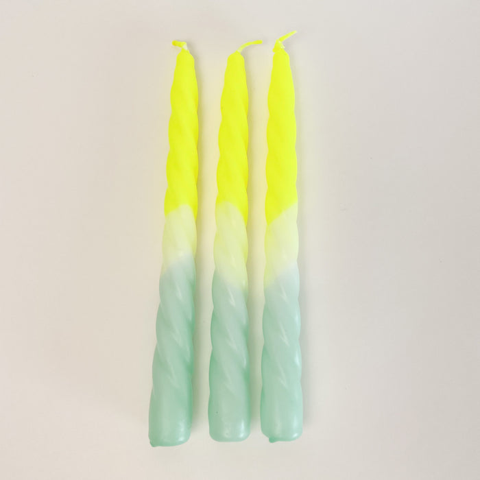 Set of 3, "Citron" Dip Dye Twisted Candles are hand dipped in a range of day glow yellow and aqua. An unexpected way to add festive color to your next table setting.  Hand dipped paraffin candles are made in collaboration with social institutions in Germany. Candles measure 9" length, 3/4" diameter. 