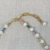 Close up of gold paper clip chain length extender.