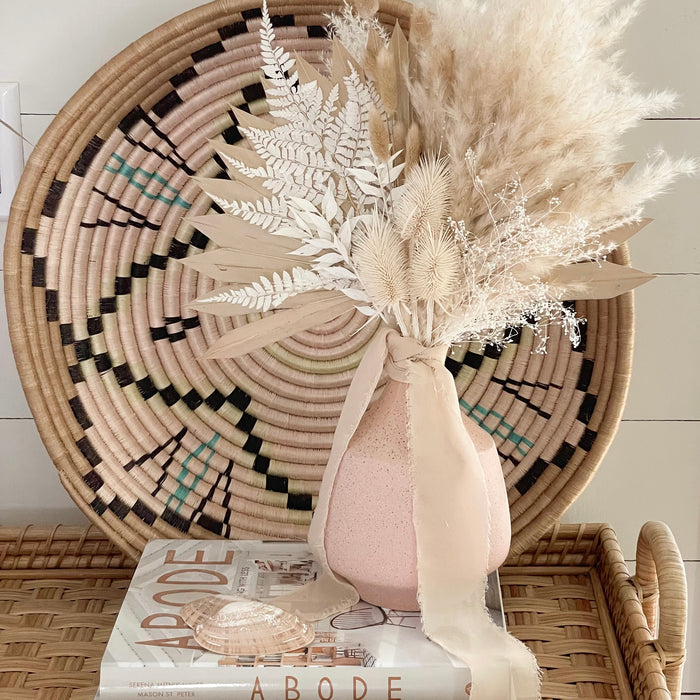 The Plateau basket shown in a pretty bohemian setting layering natural textures and shades of neutrals and blush.