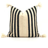 Natural cream wool pillow with bold black stripes and corner poms