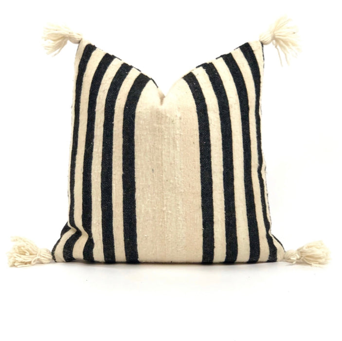 Natural cream wool pillow with bold black stripes and corner poms