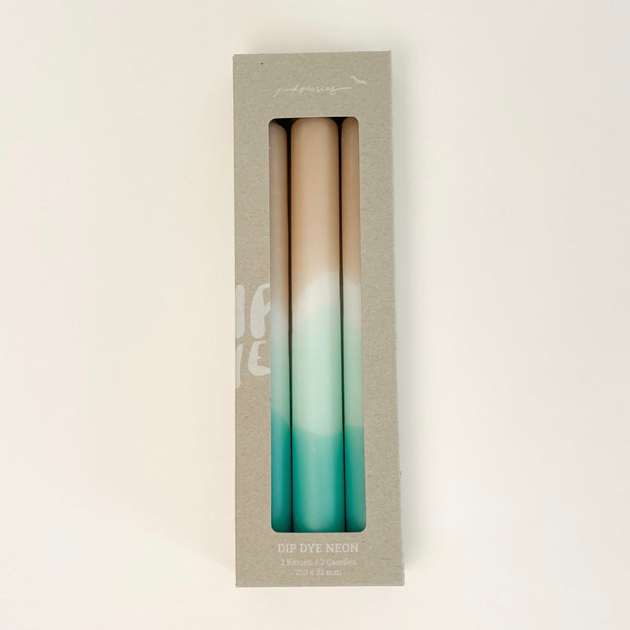Set of 3 Dip Dye Candles inspired by the shoreline and hand dipped in shades of sand, seafoam green and turquoise add coastal color to your table setting. Set of 3 come packaged in a box, perfect for a hostess gift. Hand dipped paraffin candles measure 8" length, 3/4" diameter.
