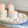 Our Whitewash Wood Platter is hand carved in Paulownia wood. Shown as a coastal centerpiece holding white candles and shells, all sold separately. A beautiful accent to modern farmhouse or coastal decor. Measures 23"L 13"W. 