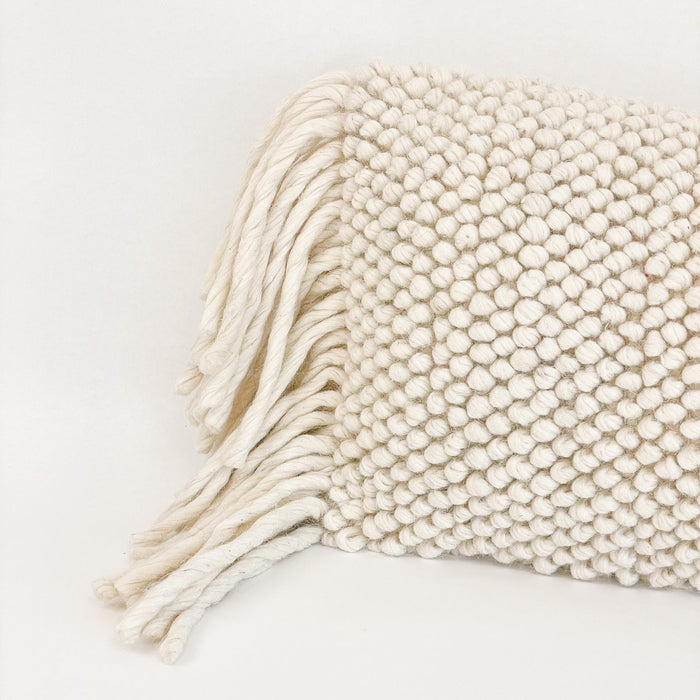 Close up of the luxe nubby texture on the Lola pillow cover. Hand made from natural cream wool. Each side is finished with long luxe wool fringe. Measures 14" x 20"