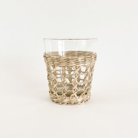 Wide seagrass tumbler. Made from recycled glass and wrapped in a hand woven seagrass cage. Measures 4.5" H 3.75" W at mouth. Perfect for the natural table.