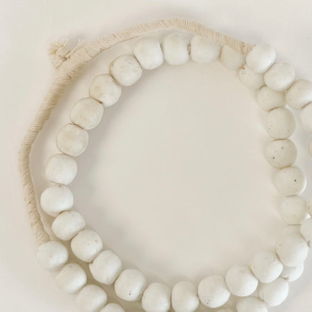 White Sandcast Beads. Hand made in Ghana from matte white glass that looks like pumice. Perfect as a decorative accent in a modern home. Approximately 26" length.
