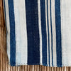 Close up of the Deep Indigo Throw showing its hand mending. This is a one of a kind vintage African textile. Hand woven in 100% cotton in a variegated indigo and natural stripe. The mending and hand stitching are part of the authenticity of this piece and should be considered part of its natural beauty. Use caution around lighter colored pieces, indigo dye may transfer to other colors. Measures 44" x 58".