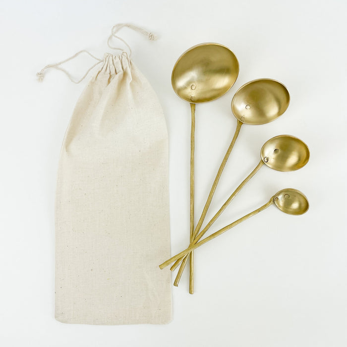 Set of 4 artisan made brass ladles. Set comes in a cotton drawstring bag. 12"L, 10.5"L, 9"L and 7.5"L. Hand wash only.