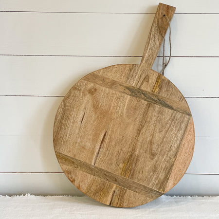 Round rustic cutting board adds farmhouse charm to any kitchen. Made of solid wood with horizontal insets. Has a jute rope hanging loop. Large, 17" diameter, 1" thick and 25" long. 
