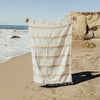The Sunny Daze Throw is woven from 100% post consumer fibers in a blend of acrylic, polyester and cotton. Sustainability meets modern California style. Natural cream blanket  has fine stripe of blue, sand and rust throughout. Perfect on the sofa or laid out on the beach. Measures 73"length, 48" width.
