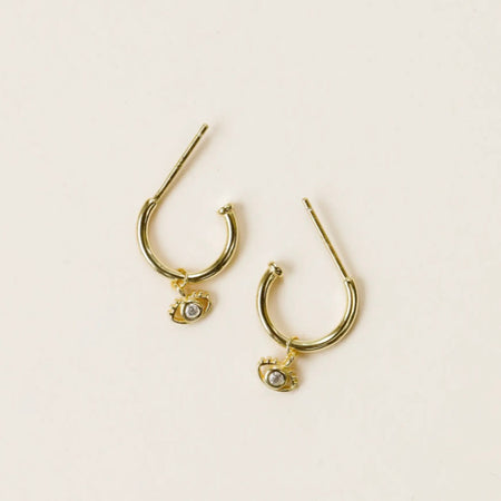 Eye on You golden hoops with a mini evil eye charm. Evil eye is said to ward off bad vibes and bring good fortune to those that wear it. Hand-crafted in 14 kt gold vermeil on a sterling silver base and finished with a clear cubic zirconia stone.