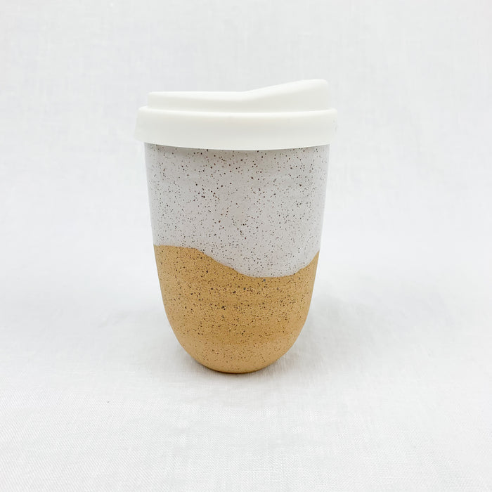 Travel mug with silicone lid. Made from natural stoneware with white speckled glaze. Holds 14 oz.