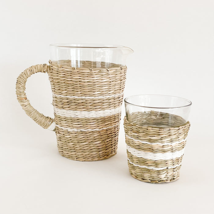 The Hamptons stripe seagrass pitcher & wide tumbler make the perfect pair on any summer table. Recycled glass is hand wrapped in a frame of natural and white seagrass in a chic stripe pattern. Artisan made. Each piece sold separately.