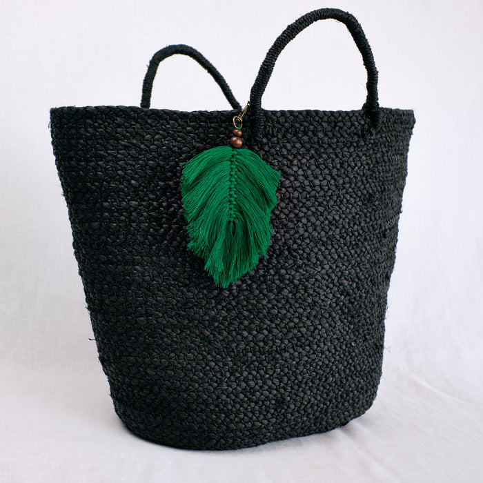green palm frond charm shown on beach bag