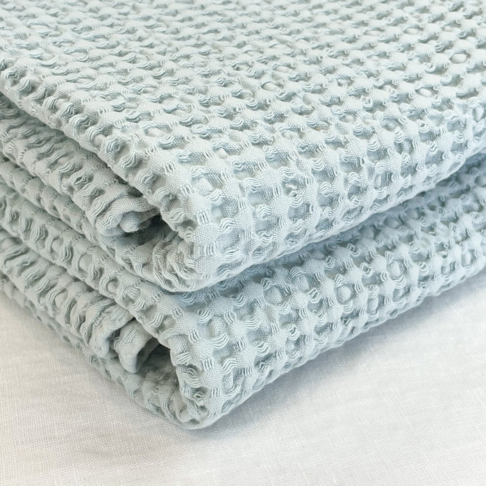 Stack of simple waffle weave towels in sky blue. Made by Hawkins NY in Portugal. Luxurious 100% cotton waffle weave stonewashed for added softness. Hand and bath towel each sold separately. 