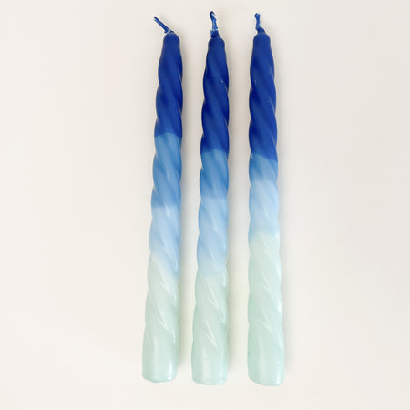 Set of 3, "Ocean" Dip Dye Twisted Candles are hand dipped in a range of mist blue, surf blue and ultra marine. They add festive color to any table setting. Hand dipped paraffin candles are made in collaboration with social institutions in Germany. Candles measure 9" length, 3/4" diameter.
