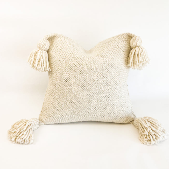 Layla pillow cover is hand made in thick natural cream wool yarns. Perfect for layering luxe texture into a modern room. Each corner is finished with a hand knotted yarn tassel. Tie back envelope closure. Measures 20" x 20"