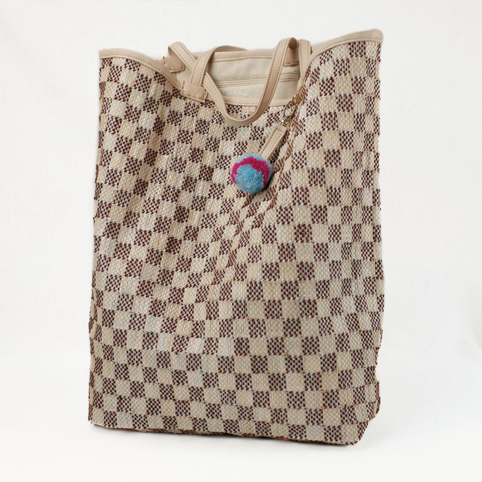 Brown and natural checkered beach tote made from a recycled grain bag. Straps and trim made of natural lamb leather.