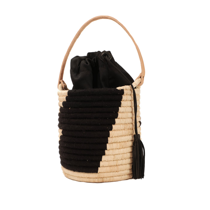 Black and natural woven raffia basket tote with natural leather handle.