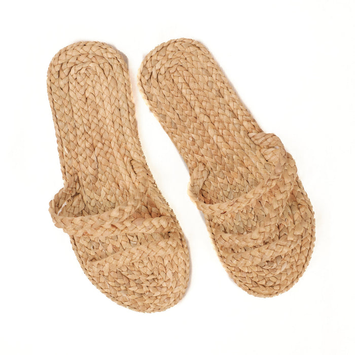Strappy slip on beach sandal made of woven raffia with a foam rubber sole.