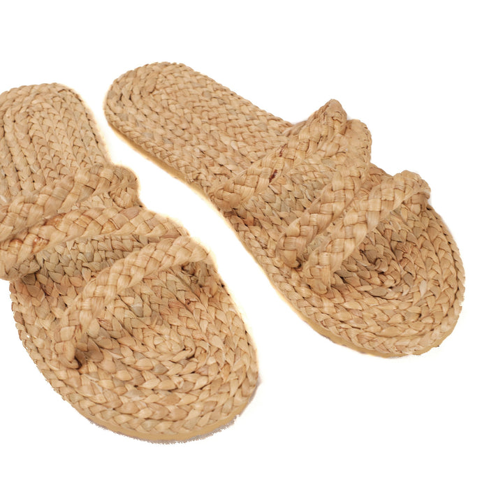 Slip on sandal made of raffia with rubber foam sole. Three straps go across the top of foot.