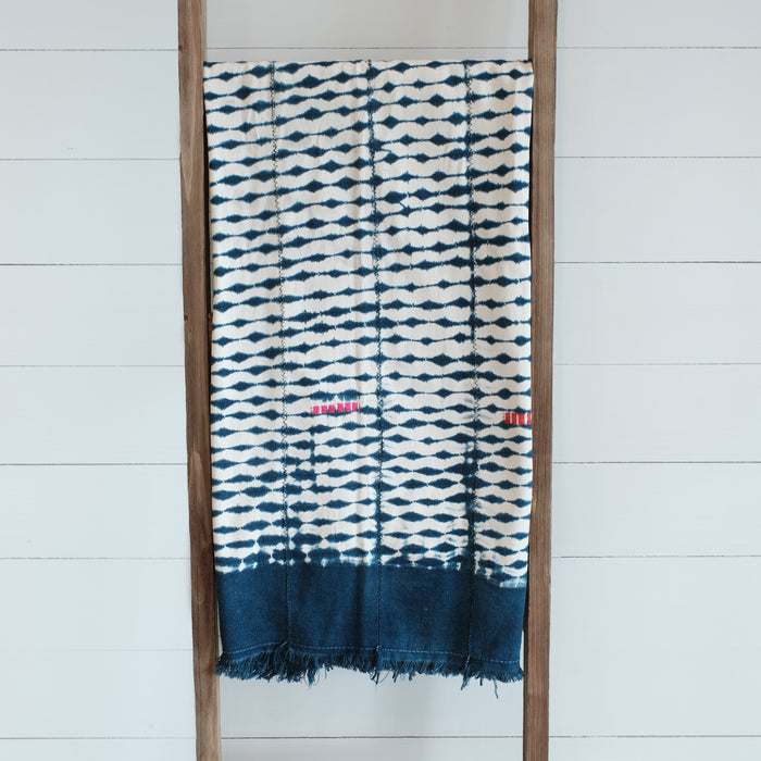 Indigo and white cotton blanket dyed with shibori technique. Wide indigo border with colorful hand stitched blocks. Vintage piece, imperfections are part of its nature.