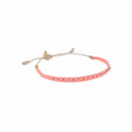 Woven friendship bracelet woven in  bright coral threads with small brass plated beads. Waxed cord adjuster for fit.