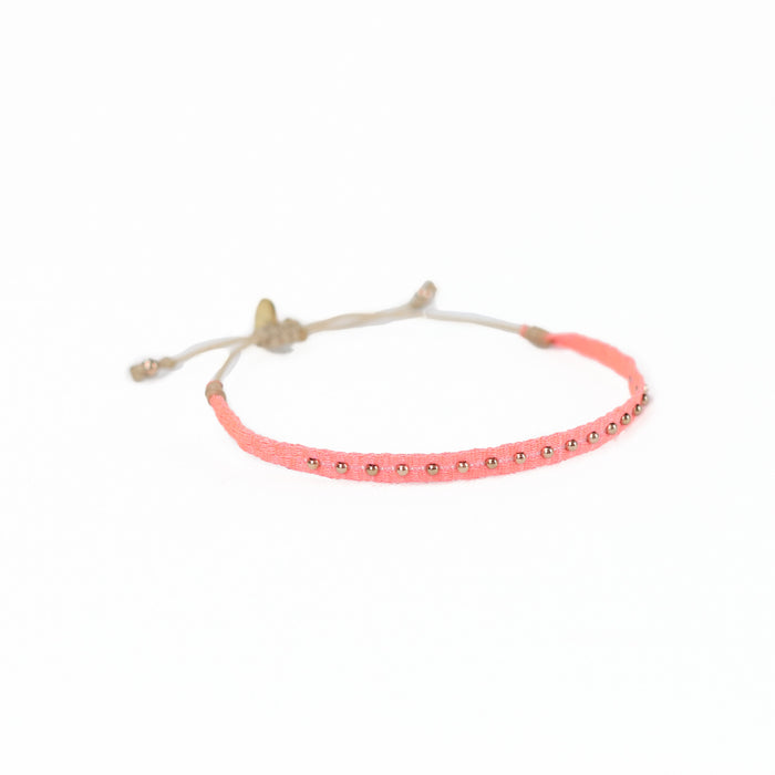 Woven friendship bracelet woven in  bright coral threads with small brass plated beads. Waxed cord adjuster for fit.